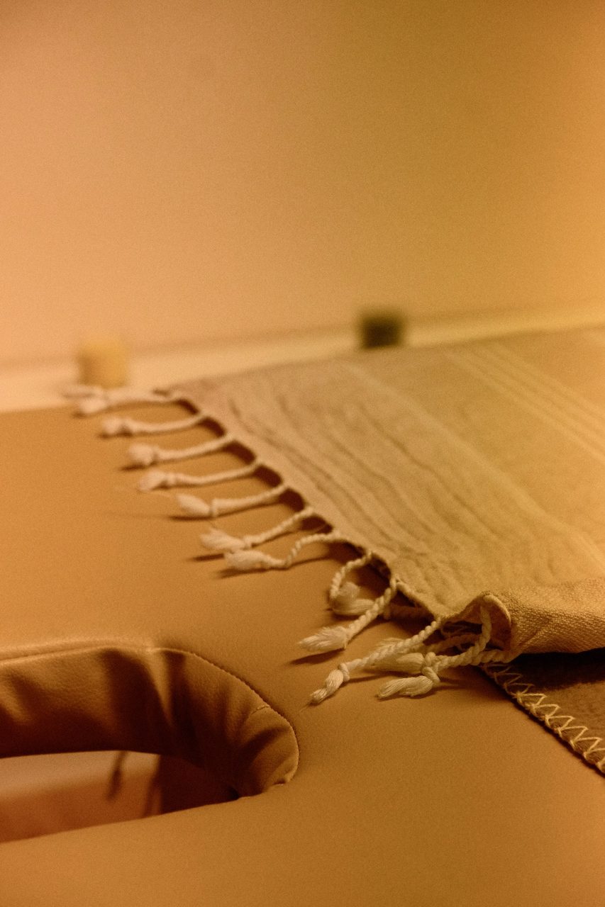 Ruhige, warme Atmosphäre im Sinnesraum mit Massageliege und Naturmaterialien